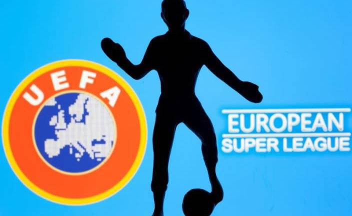 Imagen de archivo de una figura de metal de un jugador de fútbol con una pelota frente a las palabras “Superliga Europea” y el logo de la UEFA.