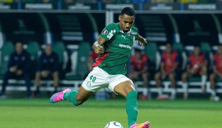 Alt: Allan Elias golpea el balón en el campo de fútbol