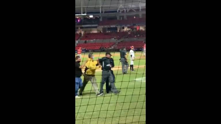 El umpire, al momento de ser sacado del terreno de juego del estadio Teodoro Mariscal, en Mazatlán