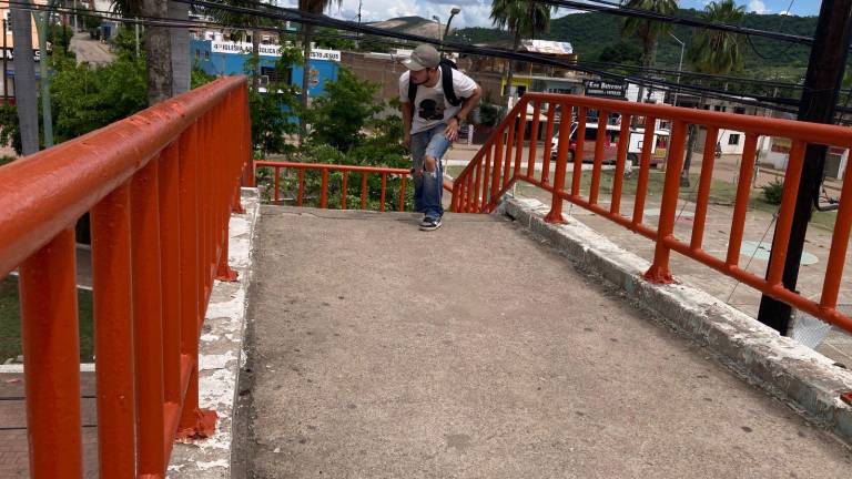 Peatones atraviesan con precaución el puente de la colonia Urías, donde un cableado mal instalado pone en riesgo su seguridad.