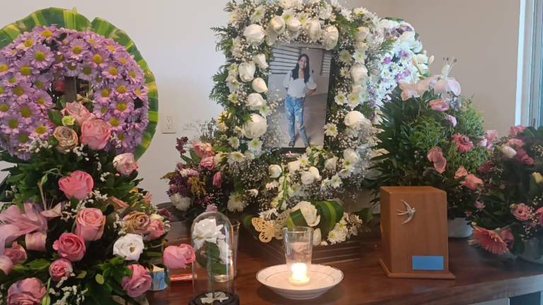 Una foto de Annyta adornada con flores ilumina la sala de su casa.