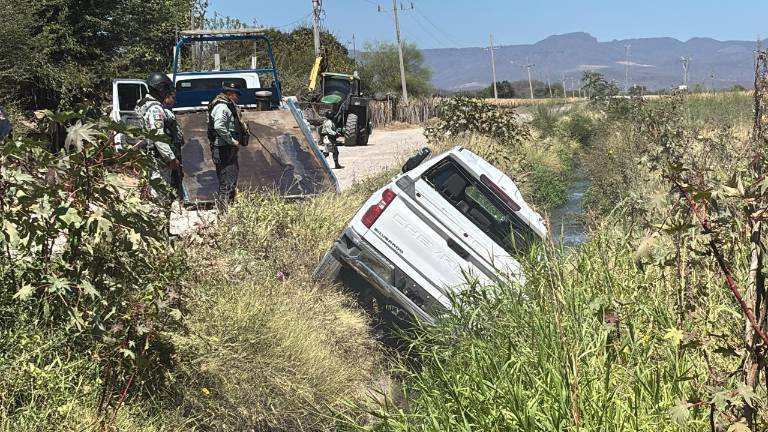 Personal de seguridad realiza maniobras para retirar el vehículo que terminó dentro de un canal.