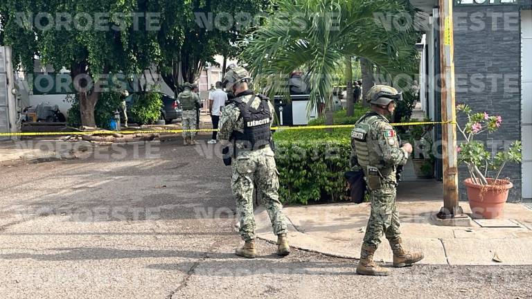 Peritos de la Fiscalía estatal realizan las diligencias tras el ataque a balazos en la vivienda.