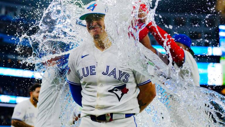 Brandon Valenzuela es bañado por sus compañeros tras definir el triunfo de los Azulejos.
