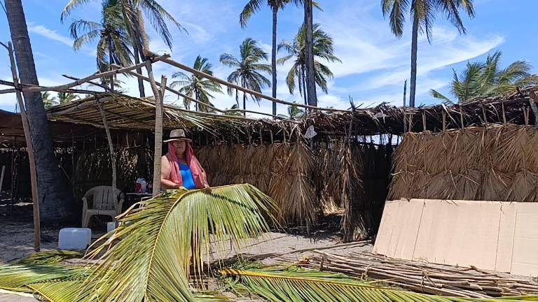 Gabriela Rodríguez ampliaba su enramada para disfrutar del día del maestro en la playa.