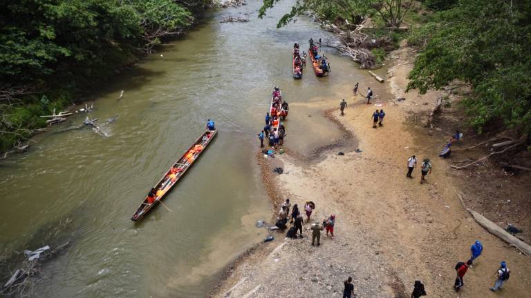 Toma aérea de migrantes que llegan en bote a Lajas Blancas sobre el río Chucunaque en la Provincia de Darién.