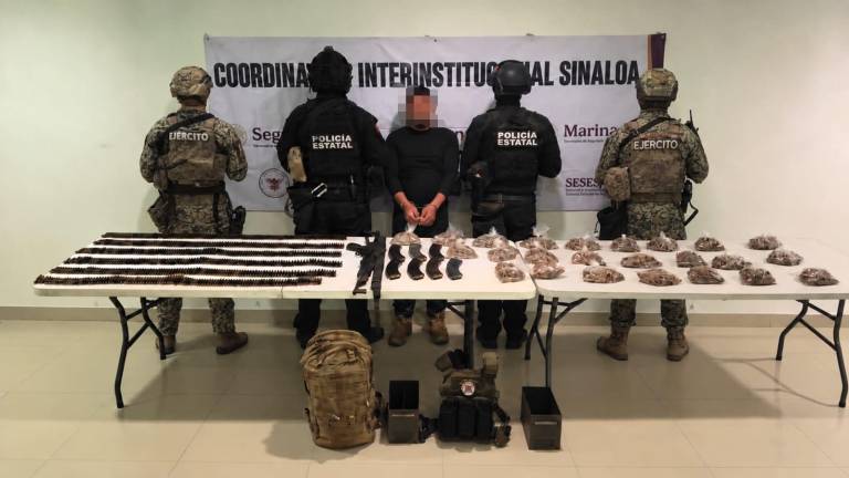 Elementos del Ejército y de la PEP resguardan al hombre detenido junto con el material bélico asegurado.