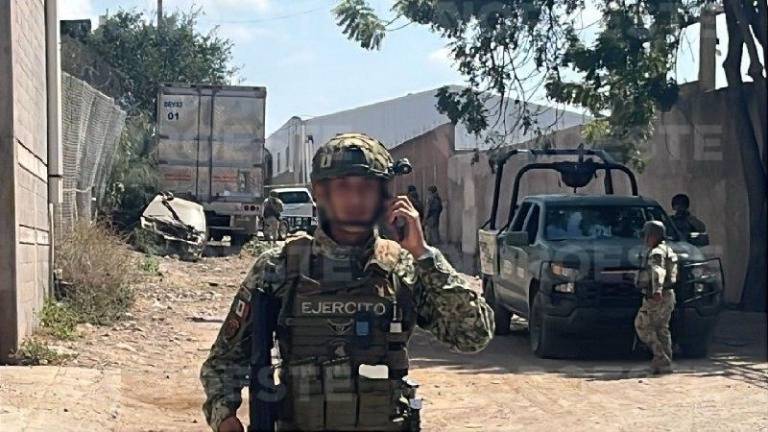 Elementos del Ejército resguardan la zona donde quedó una camioneta con impactos de bala.