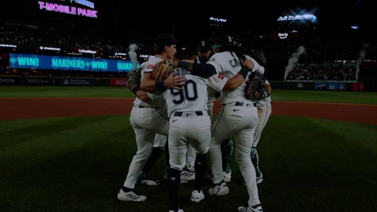 Andrés Muñoz celebra con sus compañeros tras preservar el triunfo de los Marineros.