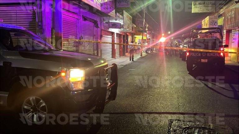 Agentes de la Fiscalía General procesan la escena del crimen en el sector Centro de Culiacán.