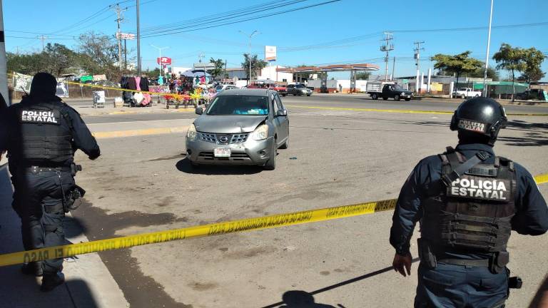 Autoridades localizan el cuerpo del hombre asesinado al interior de una camioneta, frente a una tienda.