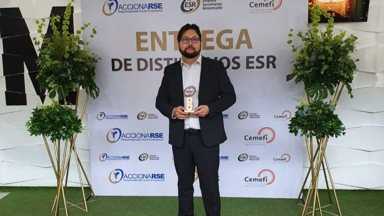 Héctor Ley Pineda, consejero de la directiva guinda, muestra el reconocimiento para Tomateros de Culiacán.
