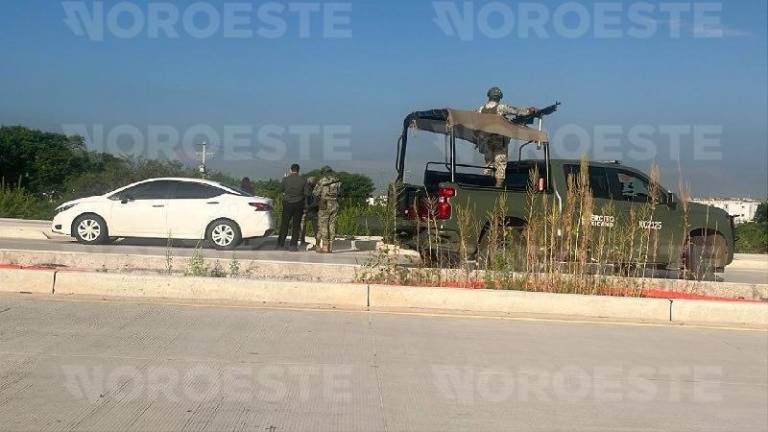 Elementos de seguridad resguardan la zona del hallazgo del joven sin vida al sur de Culiacán.