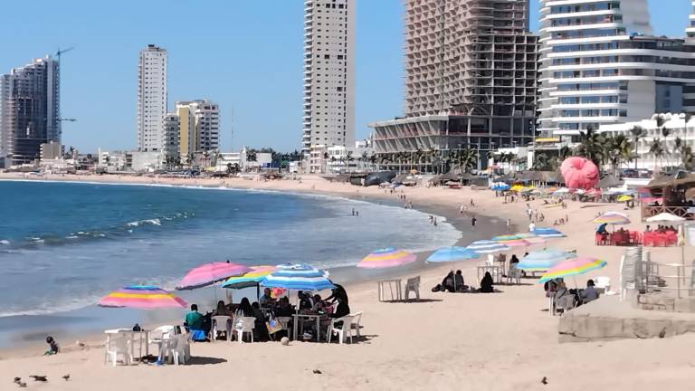 Visitantes disfrutan de la playa en Mazatlán durante el fin de semana largo, en una jornada con clima soleado y oleaje tranquilo.