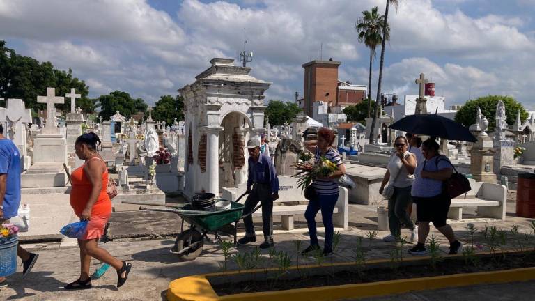 Familias enteras limpian y llevan flores a sus seres queridos.