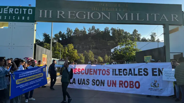 Protesta de personal activo y jubilado de la UAS por la reingeniería financiera, durante la visita de la Presidenta Claudia Sheinbaum Pardo.
