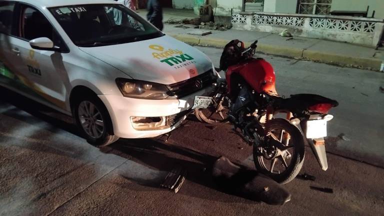 La motocicleta quedó incrustada sobre el taxi.