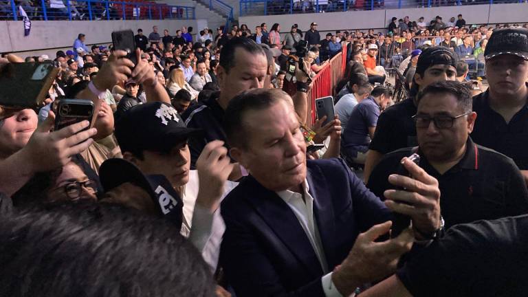 Julio César Chávez se toma fotos con los asistentes.