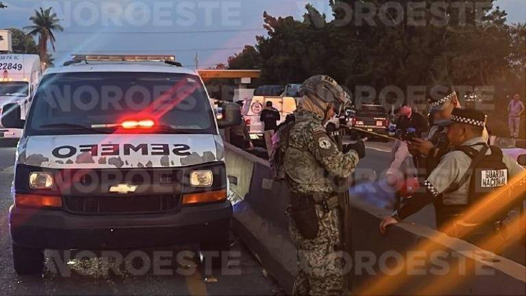 Autoridades resguardan zona donde un motociclista fue asesinado el jueves en Culiacán.