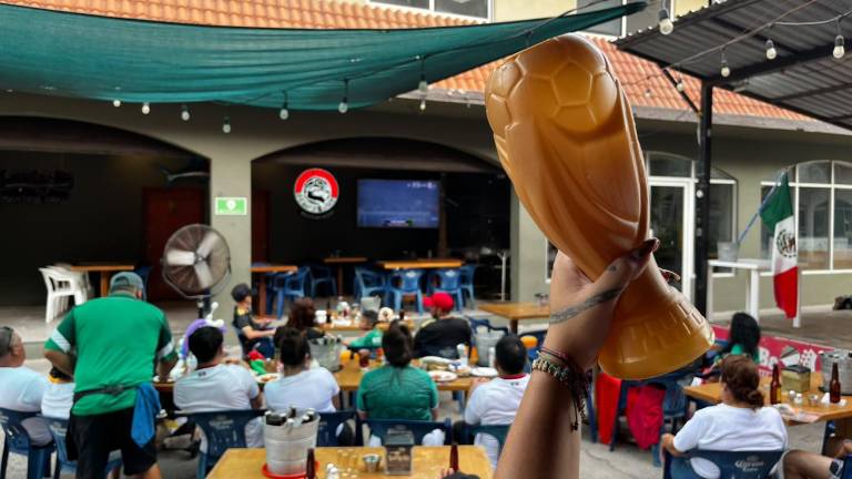 Aficionados locales y turistas disfrutan del partido en restaurantes.
