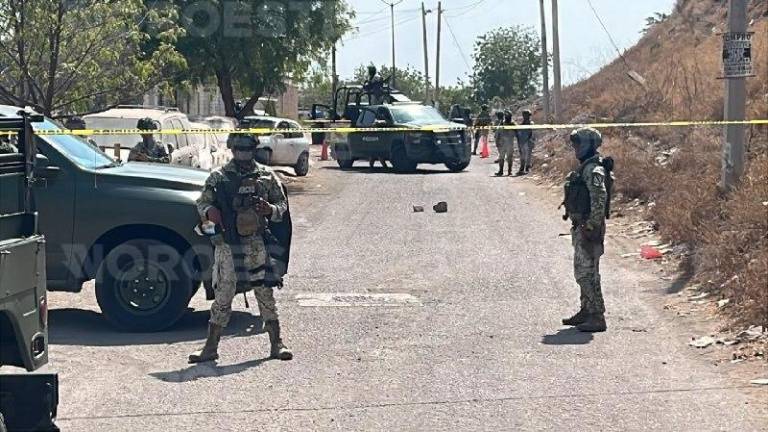 Militares resguarda el perímetro donde fue asesinado un hombre dentro de un taller mecánico.