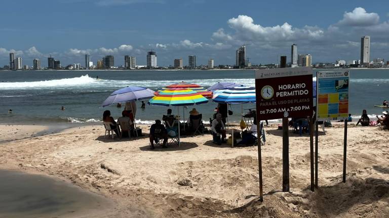 Decenas de bañistas disfrutan este domingo de la Playa Pinitos, aunque un cuerpo de aguas negras se encuentre recorriendo la zona.