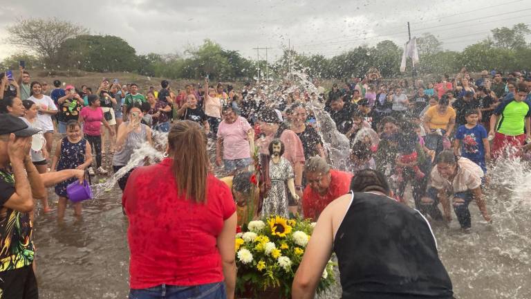 Habitantes de Villa Unión participan en el tradicional baño de San Juan en el Río Presidio.