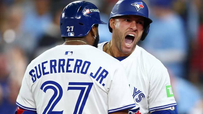 Vladimir Guerrero Jr. recibe a George Springer tras el cuadrangular decisivo que conectó para mandar a los Azulejos a la Serie Mundial.