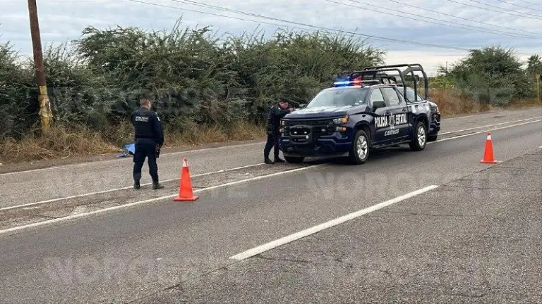 Autoridades resguardaron el área donde un hombre fue hallado sin vida a la orilla de la carretera..