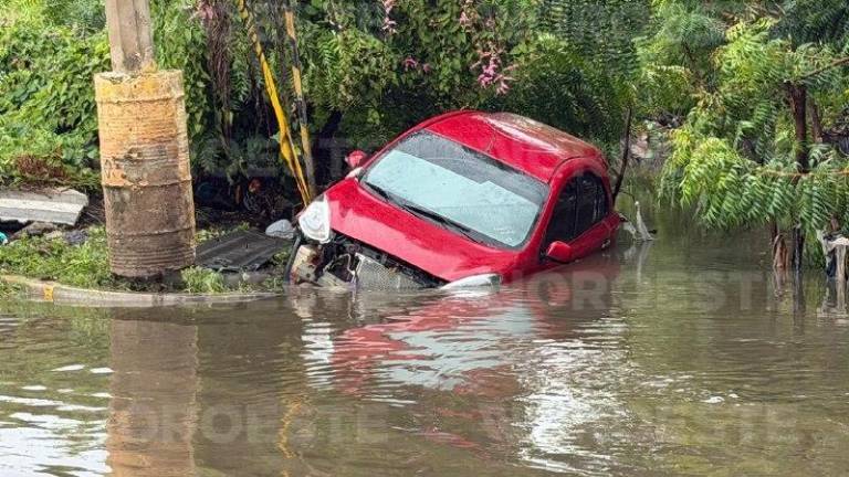 Un automóvil fue arrastrado por un arroyo en Mazatlán durante las lluvias de este jueves.