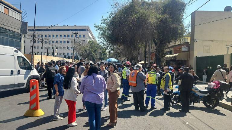 Trabajadores de Ciudad Judicial en la Ciudad de México tras ser desalojados de los edificios por una amenaza de explosivos.