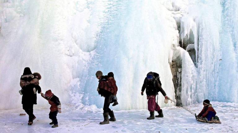 Papás llevando a sus hijos a la escuela en el Himalaya.