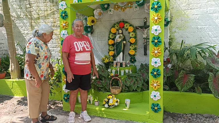 María Esperanza llena su altar de flores de papel.