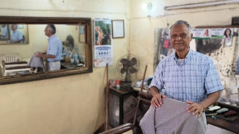 Esteban Guerra Alcantar, con sus tijeras y navajas, sigue al frente de su barbería en el mercado municipal de Rosario después de 63 años.