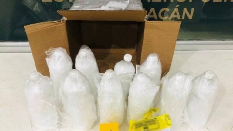 Al abrir una caja de cartón, policías localizaron 10 botellas de plástico con metanfetamina líquida.