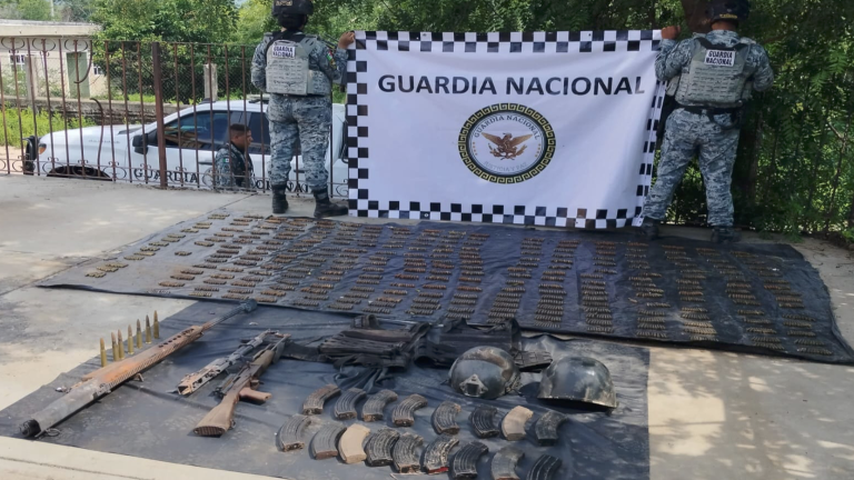 Elementos de la Guardia Nacional resguardan las armas y cartuchos asegurados.