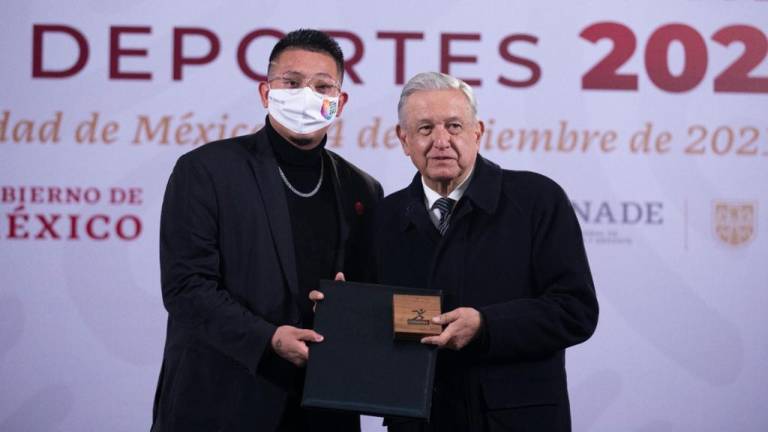 El lanzador Julio Urías recibe su premio de parte de Andrés Manuel López Obrador.
