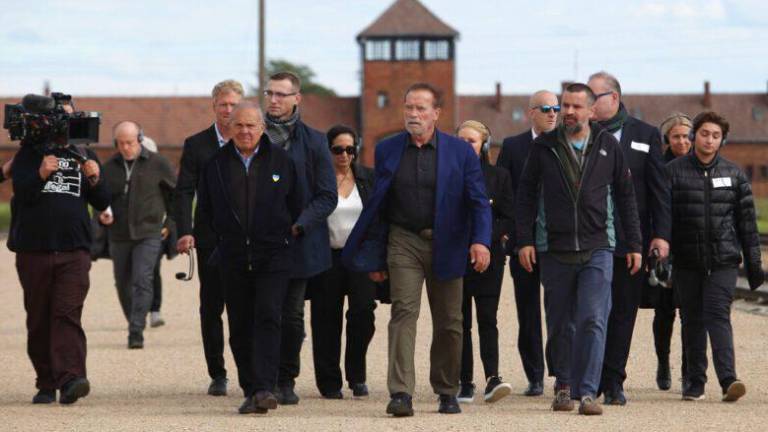 El actor Arnold Schwarzenegger recorre Auschwitz, un campo de prisioneros Nazi.