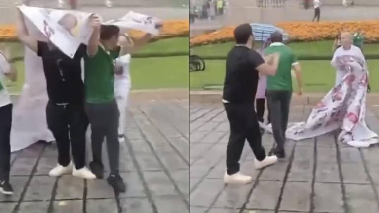 Durante los festejos del triunfo de la Selección Mexicana en el Ángel del Independencia, dos aficionados arrebataron una lona con fichas de búsqueda a activistas, para cubrirse de la lluvia.