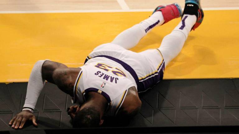 LeBron James se duele tras torcerse su tobillo derecho en el duelo que los Lakers perdieron ante los Hawks.