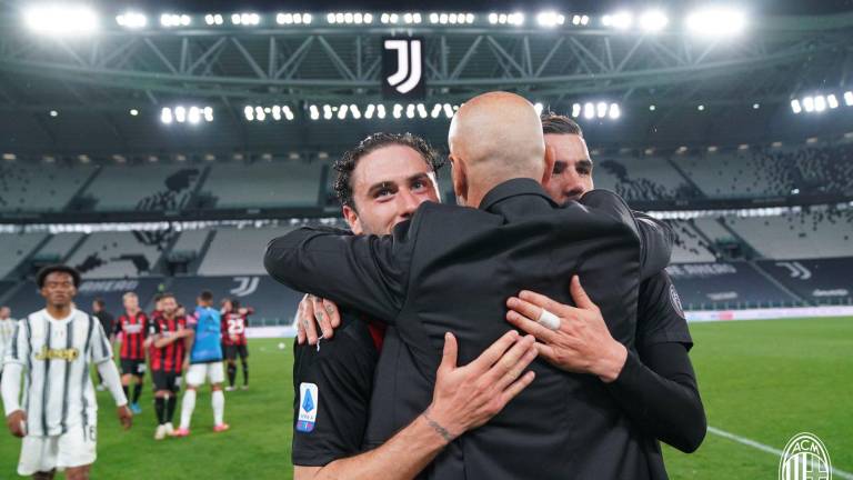 Los jugadores del Milán se abrazan con su entrenador al término del encuentro ante la Juventus.