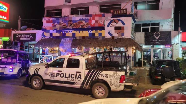 Policías municipales y personal pericial resguardaron el hotel donde fue localizada sin vida una mujer en la Zona Dorada.