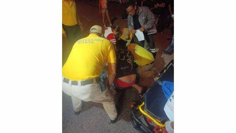 Personal de emergencia de Rosario atiende a un motociclista lesionado tras chocar con un perrito.