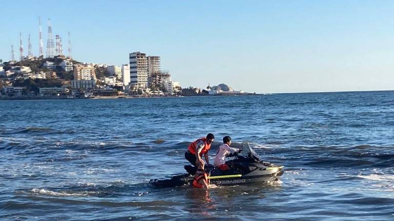 La pareja es rescatada del mar tras caer de un parachute.