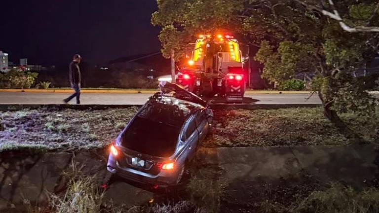 El vehículo, que terminó volcado, fue sacado del canal pluvial con apooyo de una grúa.