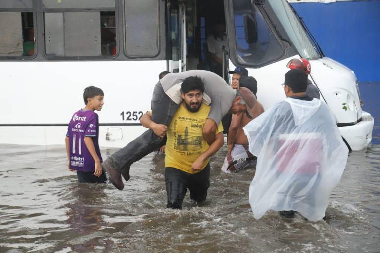 Se vara camión en avenida inundada y rescatan a pasajeros en Mazatlán