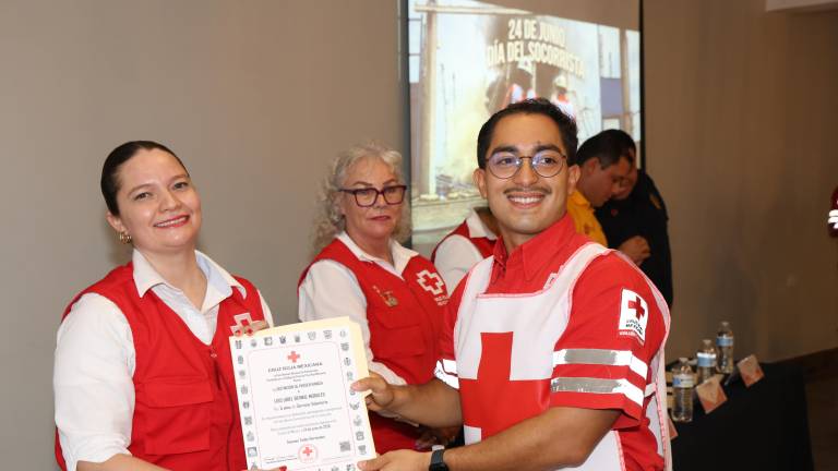 Isabel Arce Muñoz, coordinadora local del voluntariado, hace entrega del diploma a Luis Uriel Bernal.