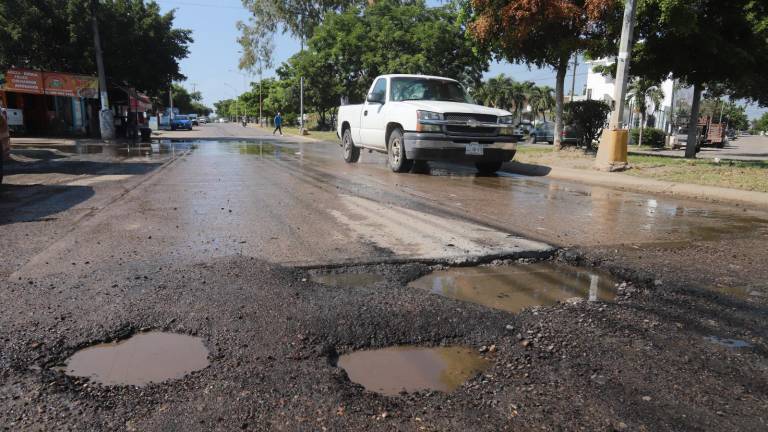 Los baches en la avenida Jacarandas han provocado caos y pleitos a golpes entre conductores.