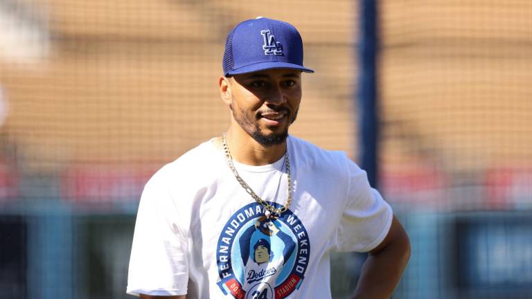 Los peloteros de Dodgers salen a calentar con sus playeras conmemorativas.