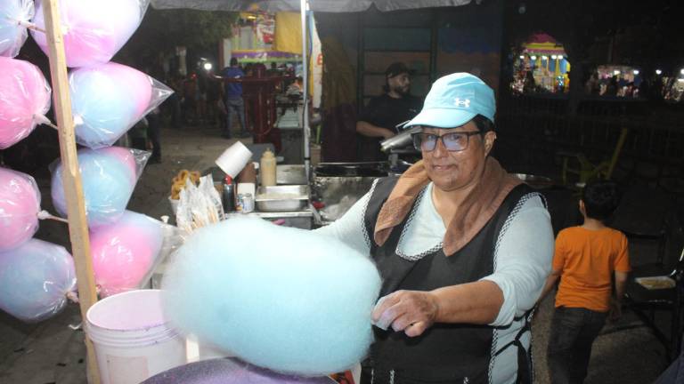 Belén Hernández Amador elabora algodón de azúcar durante su jornada como comerciante en ferias populares.